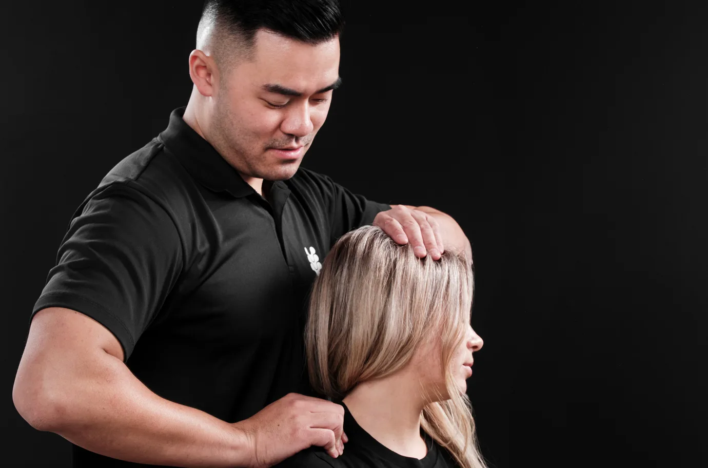 A practitioner at The Spinal Studio assessing a client's neck and shoulder