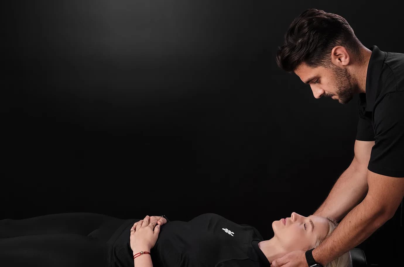 A physiotherapist from The Spinal Studio working with a client lying on a bench