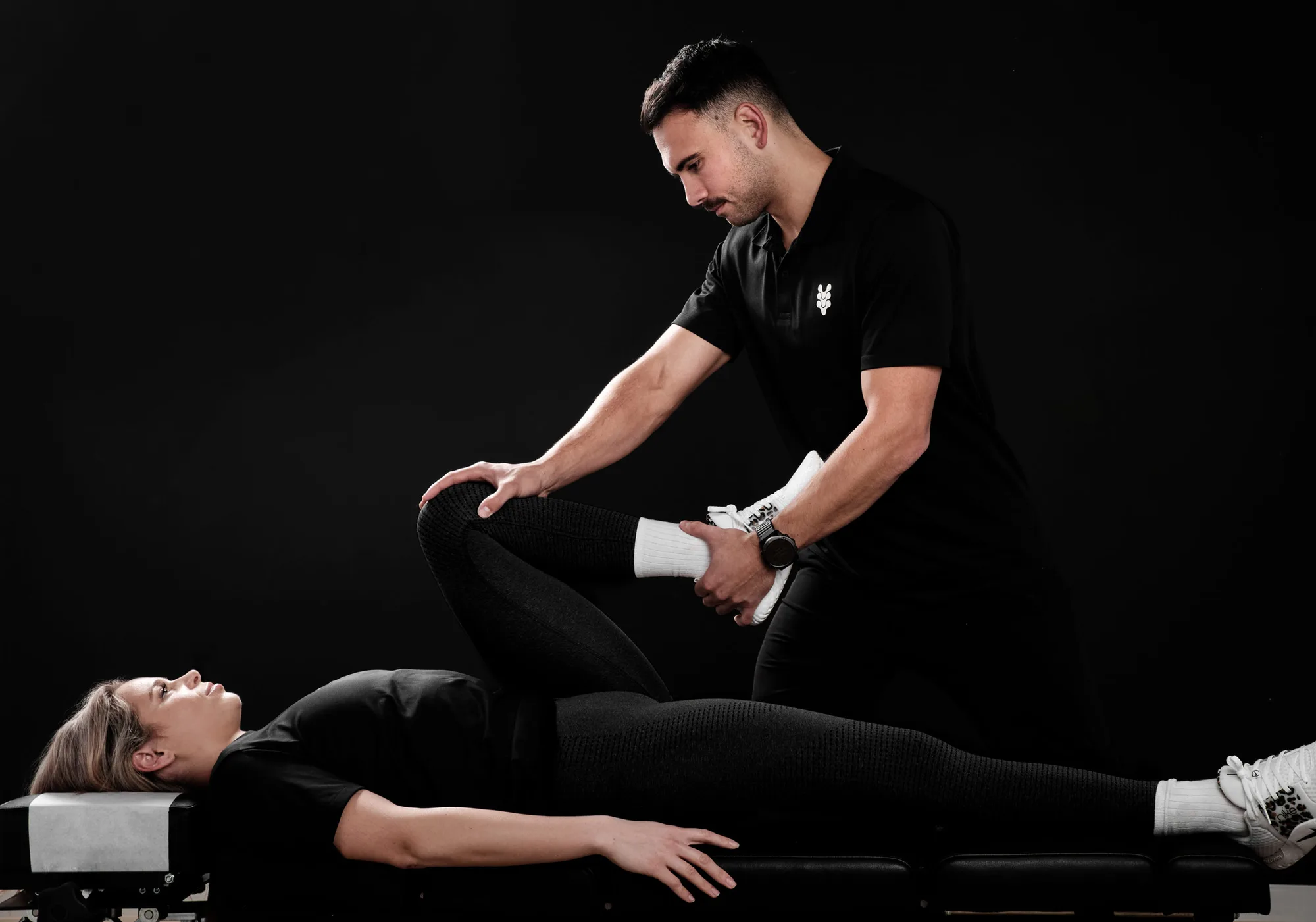 A practitioner moving a client through a hip stretch at The Spinal Studio